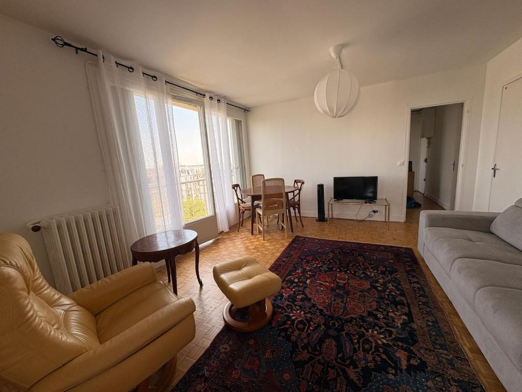 a living room with a couch and a table at Apartment in the sky of Paris in Paris
