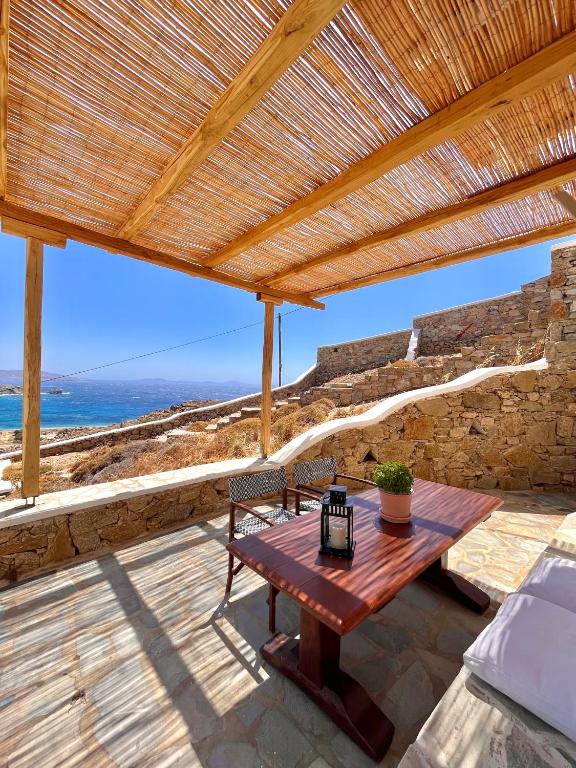 a wooden table on a patio with a view of the ocean at Akra in Houlakia