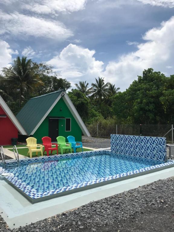 Family Cottage Beseri في كانجار: مسبح مع كراسي ملونة ومنزل