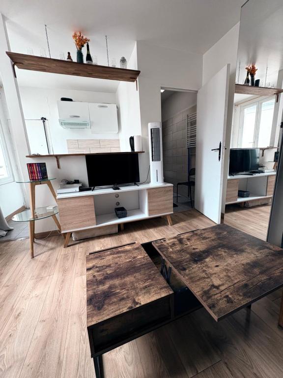 - un salon avec une télévision et une table en bois dans l'établissement Studio equipé, lumineux a Paris, à Paris