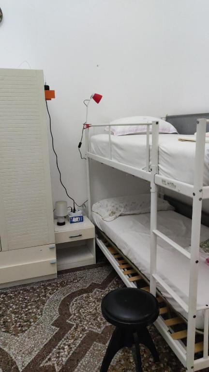 a bedroom with two bunk beds and a stool at Hostello Genovese in Genova