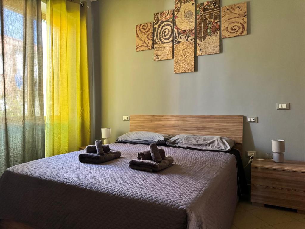 two pairs of slippers sitting on a bed in a bedroom at casa Martina - LuxRental Apartments in Pescara
