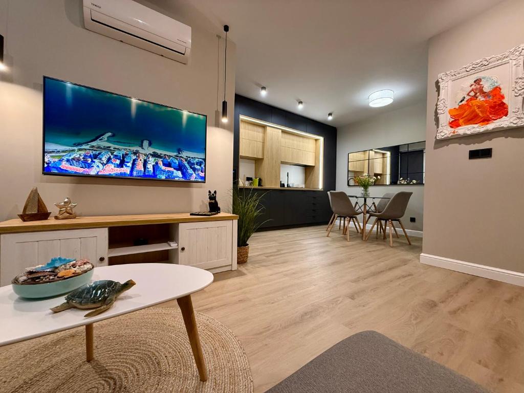 a living room with a large flat screen tv on the wall at Апартамент Vista Al Mar in Pomorie