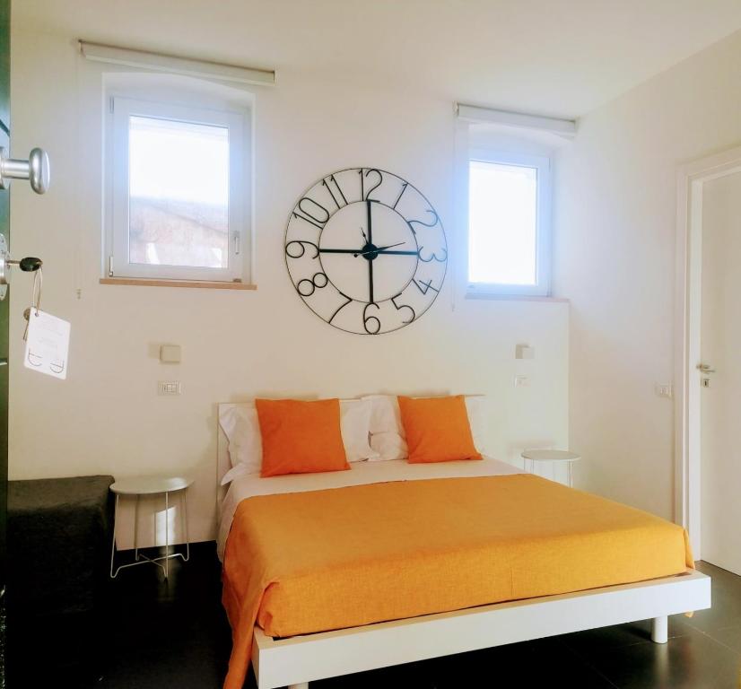 una camera da letto con un letto con un grande orologio sul muro di PM 5 Via Salita di Castelvecchio a Matera
