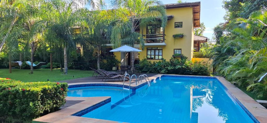 a swimming pool in front of a building at Villa do Cajueiro Imbassaí by LVF in Imbassai
