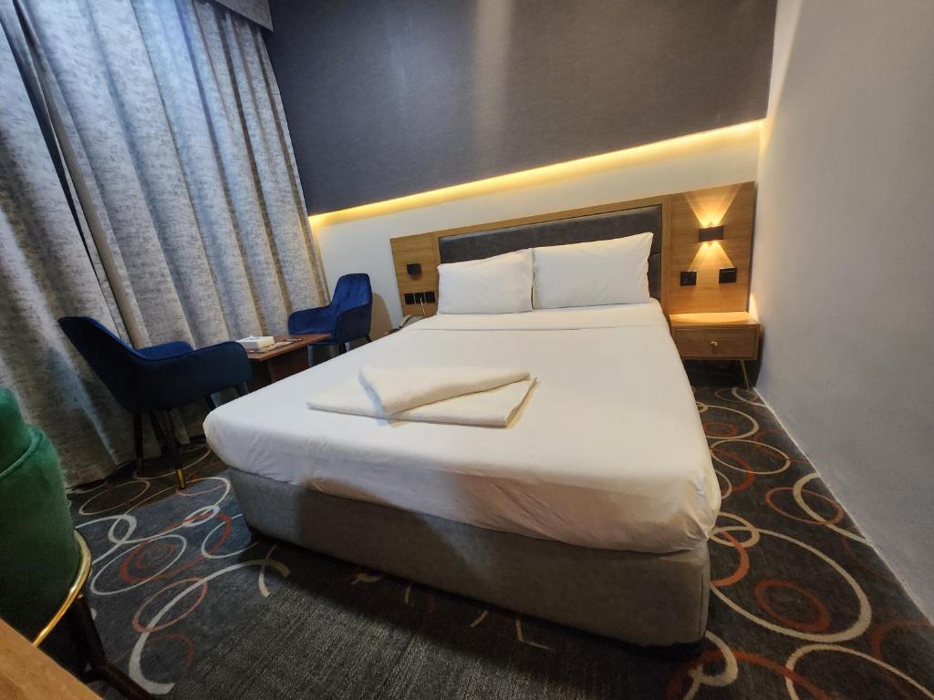 a hotel room with a large bed and a desk at Melody Queen Hotel by AURA in Dubai