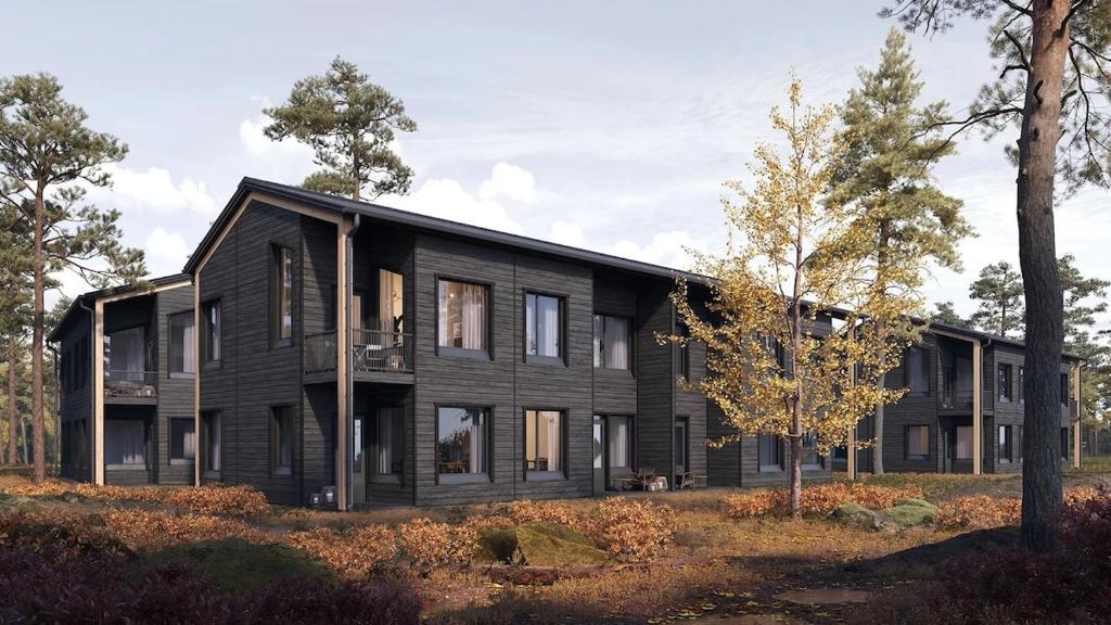 a black house in the middle of a forest at Levin Lyhty Bianca by Hilla Villas in Levi
