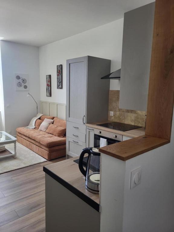 a kitchen and living room with a couch in the background at Les échappées de Senonches in Senonches