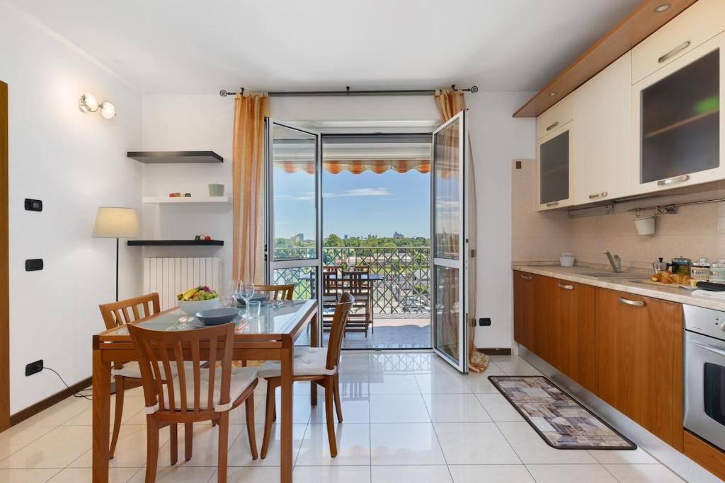 a kitchen and dining room with a table and chairs at Elegant Terrace Flat Parking near Rho Fiera Mi in Milan