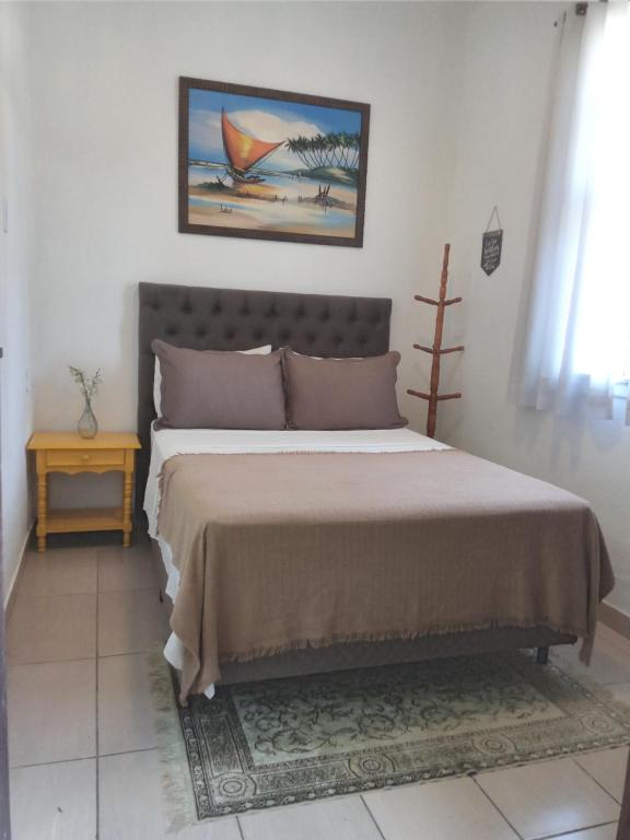 a bedroom with a bed with a painting on the wall at Apartamento perto do Palácio de Cristal in Petrópolis