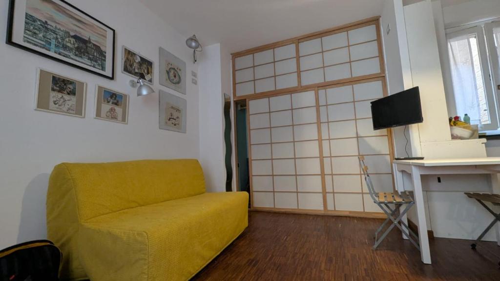 a living room with a yellow couch and a window at Charme Ticinese Navigli house e free wifi in Milan