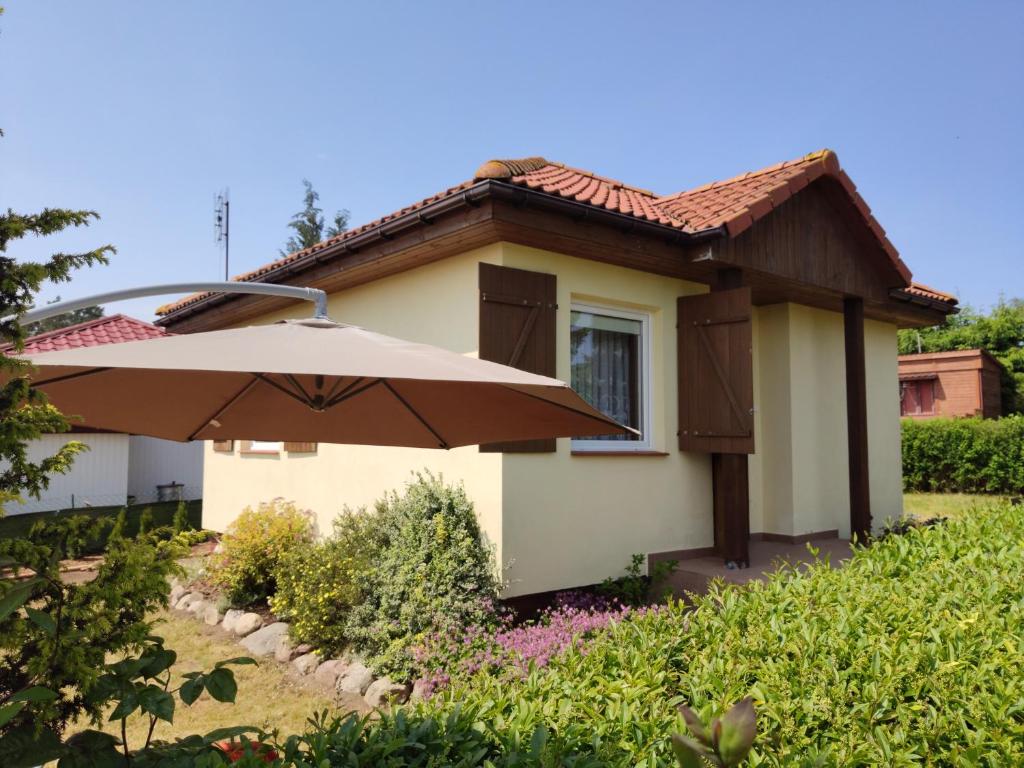 una casa con un ombrello davanti di Domek letniskowy nad morzem a Jarosławiec