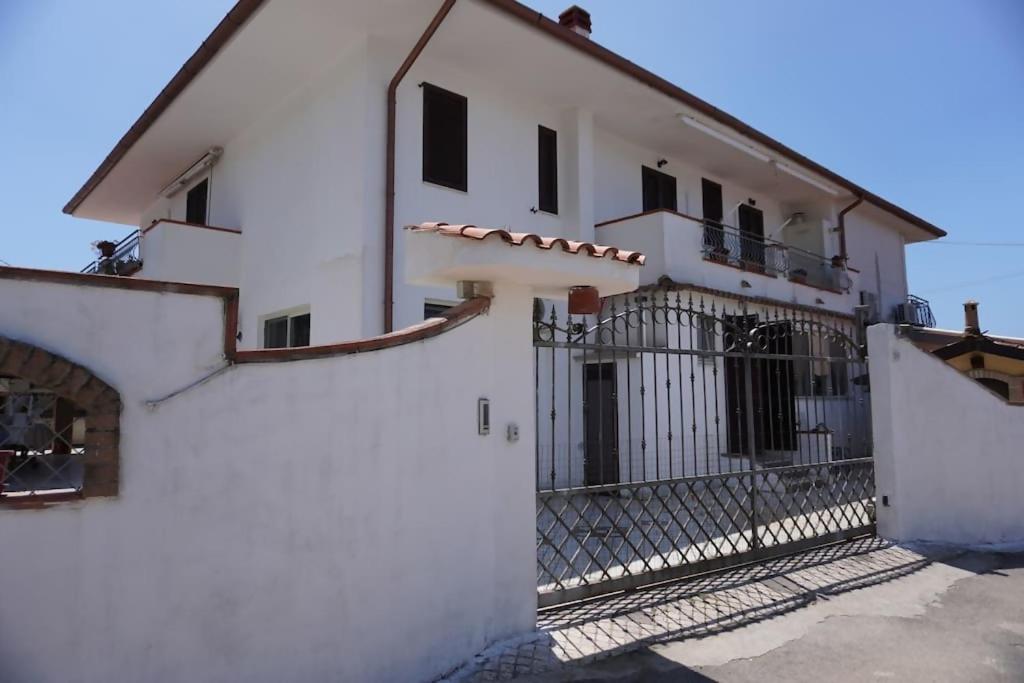 a white building with a gate and a fence at Villa 7 posti a 3 minuti dal mare - Villa Carbone in Sperlonga