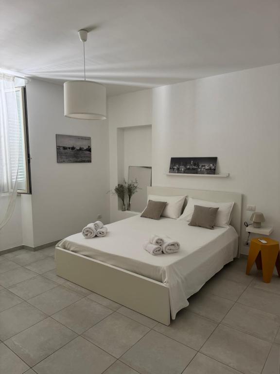 a white bedroom with a large white bed in it at Una Finestra tra i Vicoli - appartamento nel cuore di Vasto in Vasto