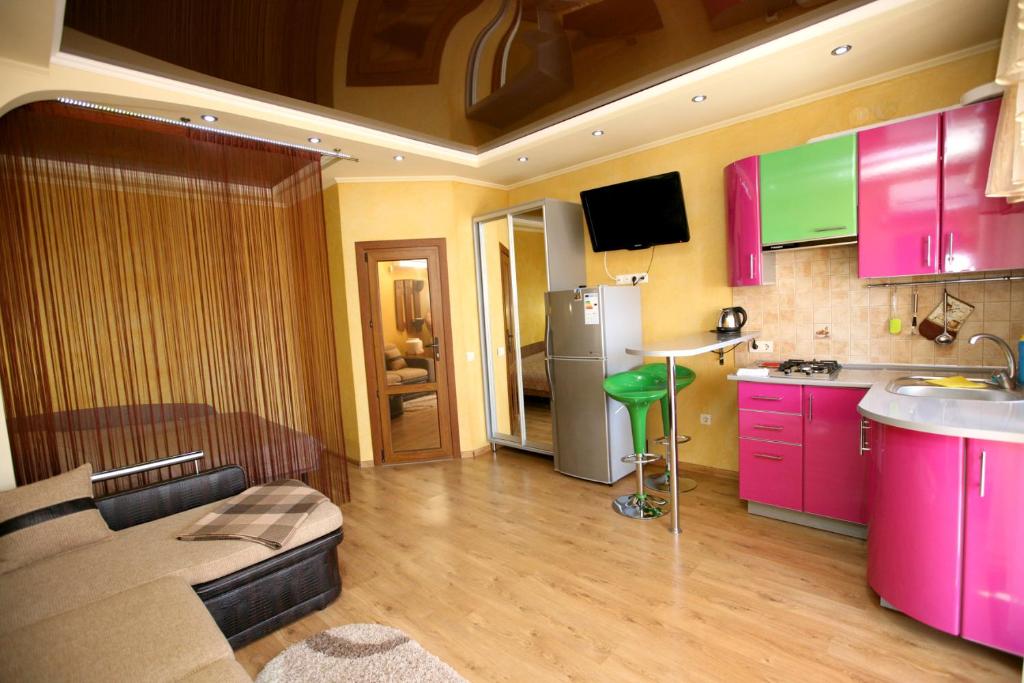 a kitchen with pink cabinets and a living room at Guest House Viktoria&Vladimir in Novyy Svet