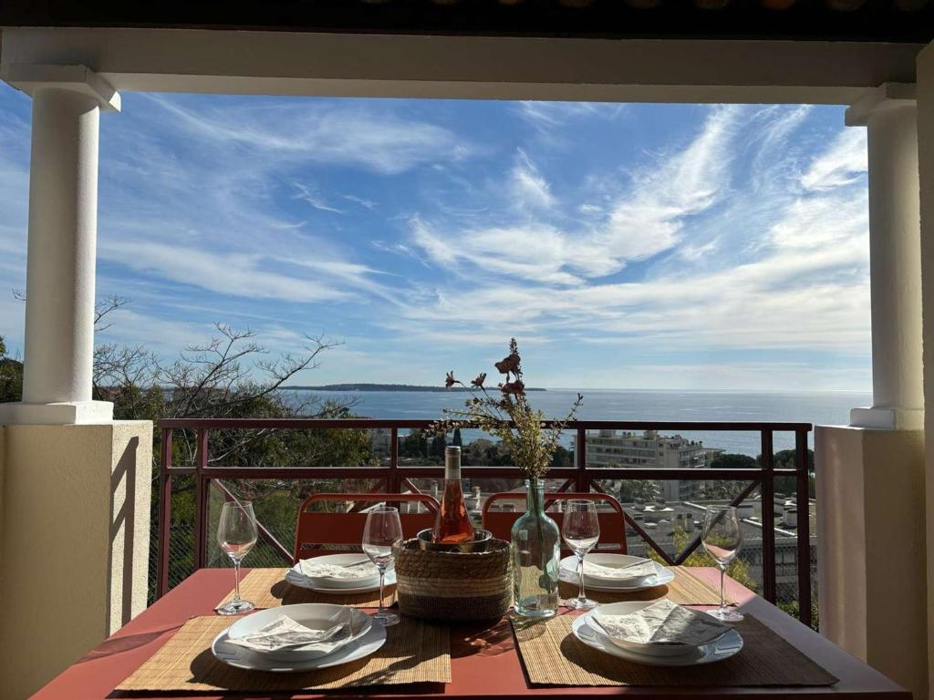- une table avec des verres à vin et une vue sur l'océan dans l'établissement Studio cabine 5 pers, piscine, parking, tennis, Cannes la Bocca - FR-1-609-106, à Cannes