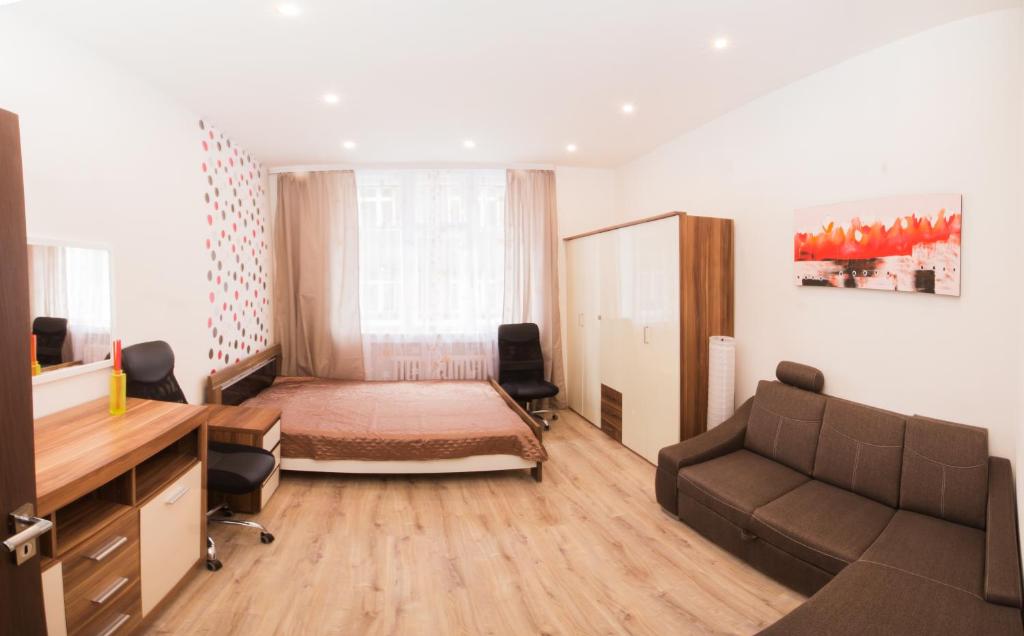 a bedroom with a bed and a desk and a couch at Apartment Ve Smeckach with a big Terrace in Prague