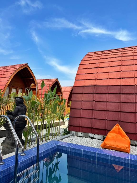 a house with a swimming pool next to a building at Lokasea Villa Bali in Pengastulan