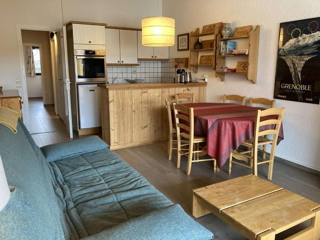 une cuisine et un salon avec une table et un canapé dans l'établissement Appartement cosy 6 pers, centre Alpe d'Huez, proche pistes/activités, balcon sud - FR-1-405-359, à Huez