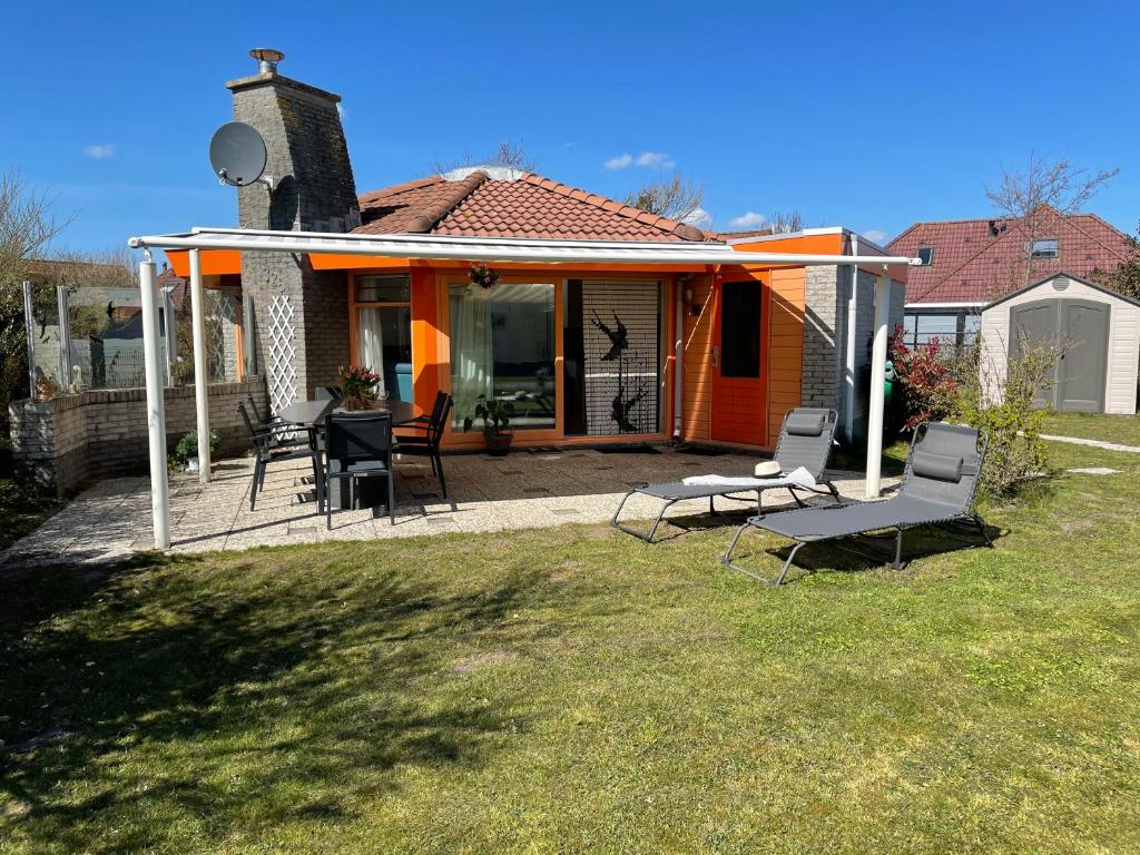 a house with chairs and an orange roof at Zeester 325 in Julianadorp