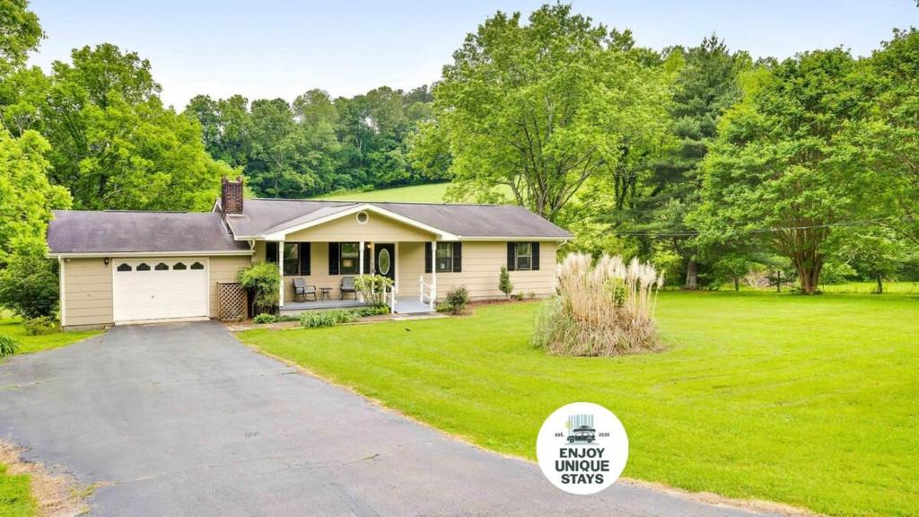 a house with a driveway in a yard at Country Lane Cottage- privacy & quiet neighborhood in Rossville