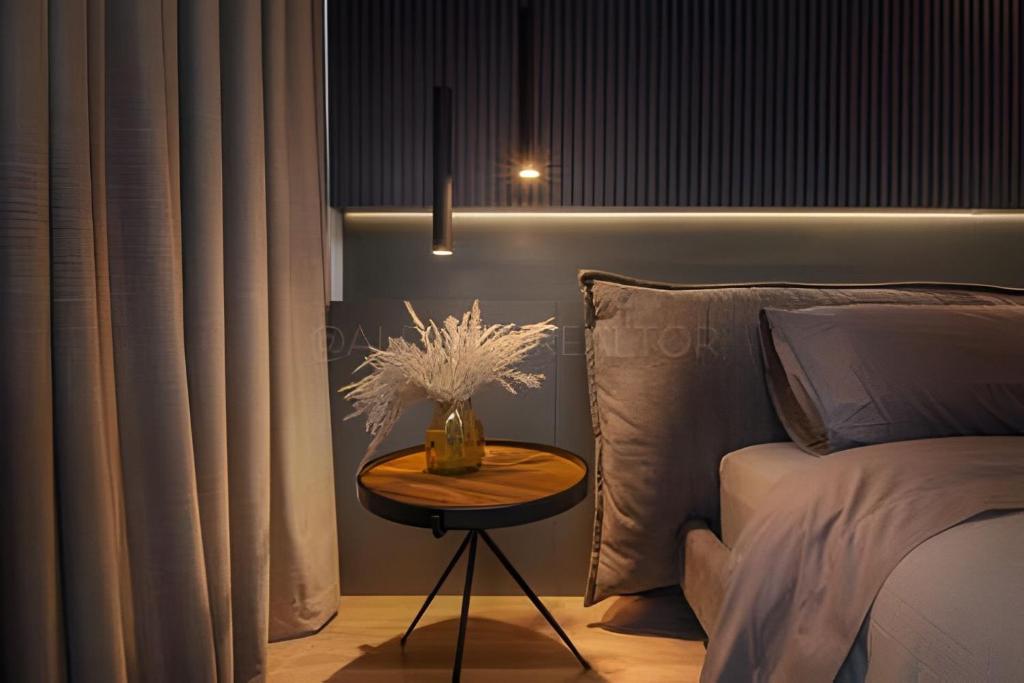 een slaapkamer met een bed en een tafel met een vaas erop bij Parma 2305 - Elegance in the Urban Heart / Poblado in El Poblado