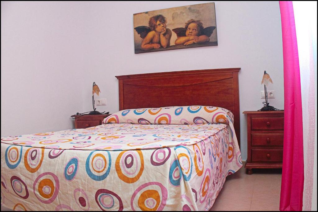 コニル・デ・ラ・フロンテーラにあるApartamento Pascual Junquera Iのベッドルーム1室(ベッド1台付)が備わります。壁には絵画が飾られています。
