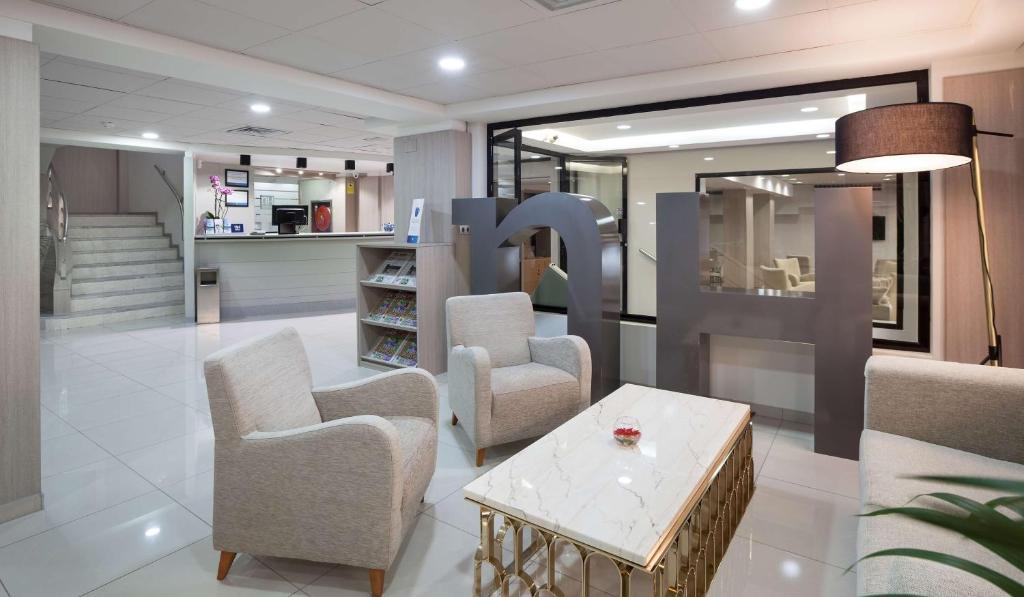 een winkel met stoelen en een tafel in een kamer bij NH Las Palmas Playa las Canteras in Las Palmas de Gran Canaria