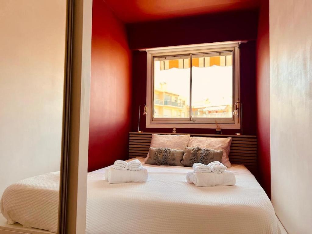 a bedroom with a bed with two towels on it at joli T2 central rénové in Menton