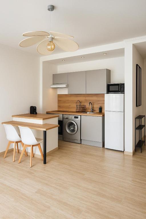 a kitchen with a table and a dining room at joli T2 central rénové in Menton