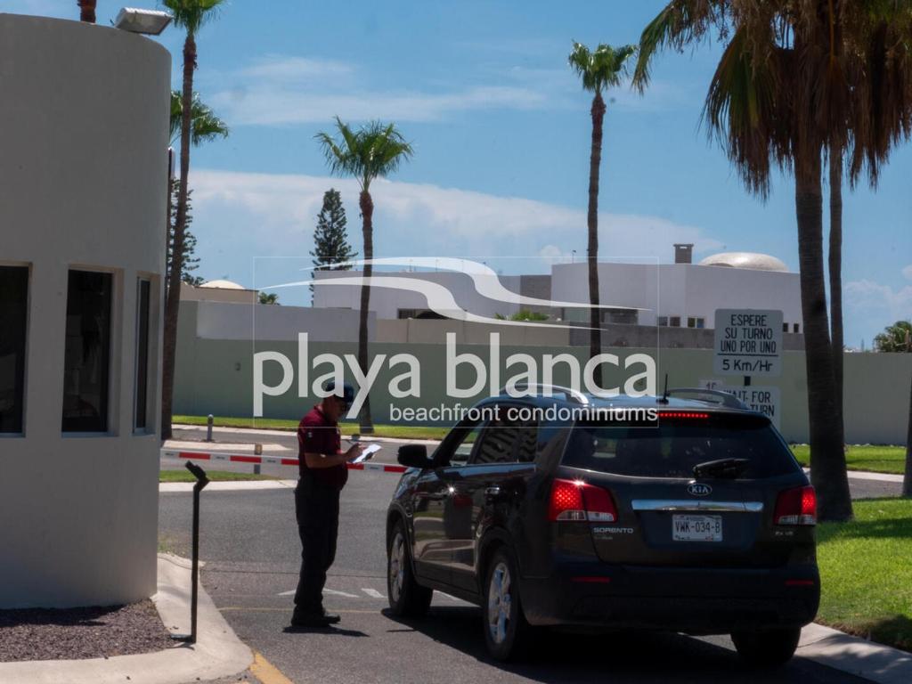 a police officer is standing next to a car at Playa Blanca Premier Unit 103 in Isla Venado
