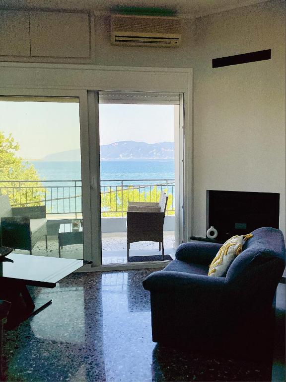 a living room with a couch and a view of the ocean at Sea breeze in Nafpaktos