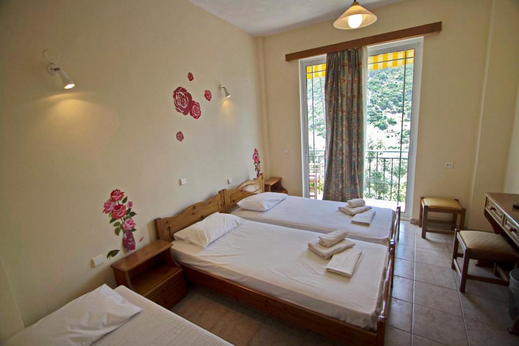1 dormitorio con 2 camas y ventana en Sunset Crete en Kámbos