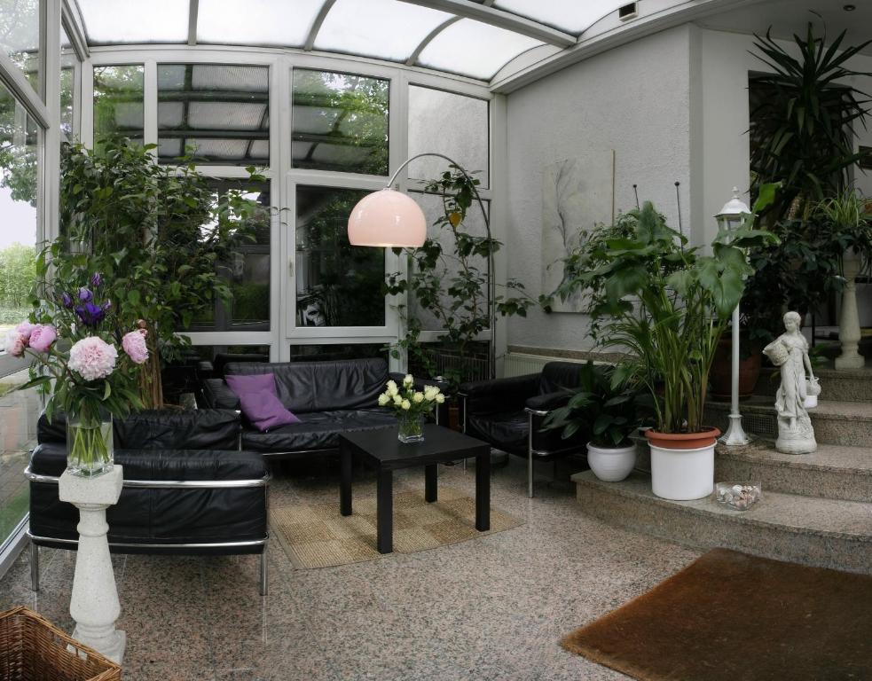 un salon rempli de nombreuses plantes dans l'établissement Hotel Eilenriede, à Hanovre