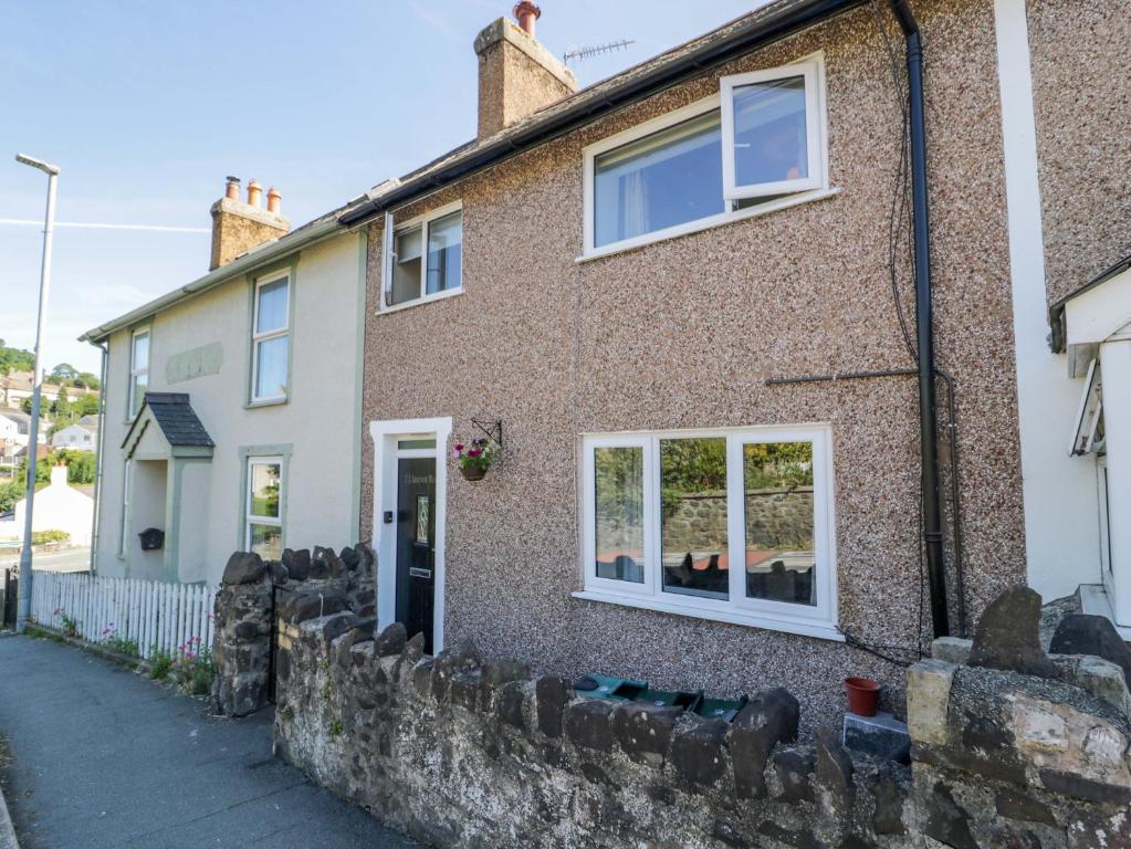 a brick house with white windows on a street at Bryn Hyfryd in Conwy