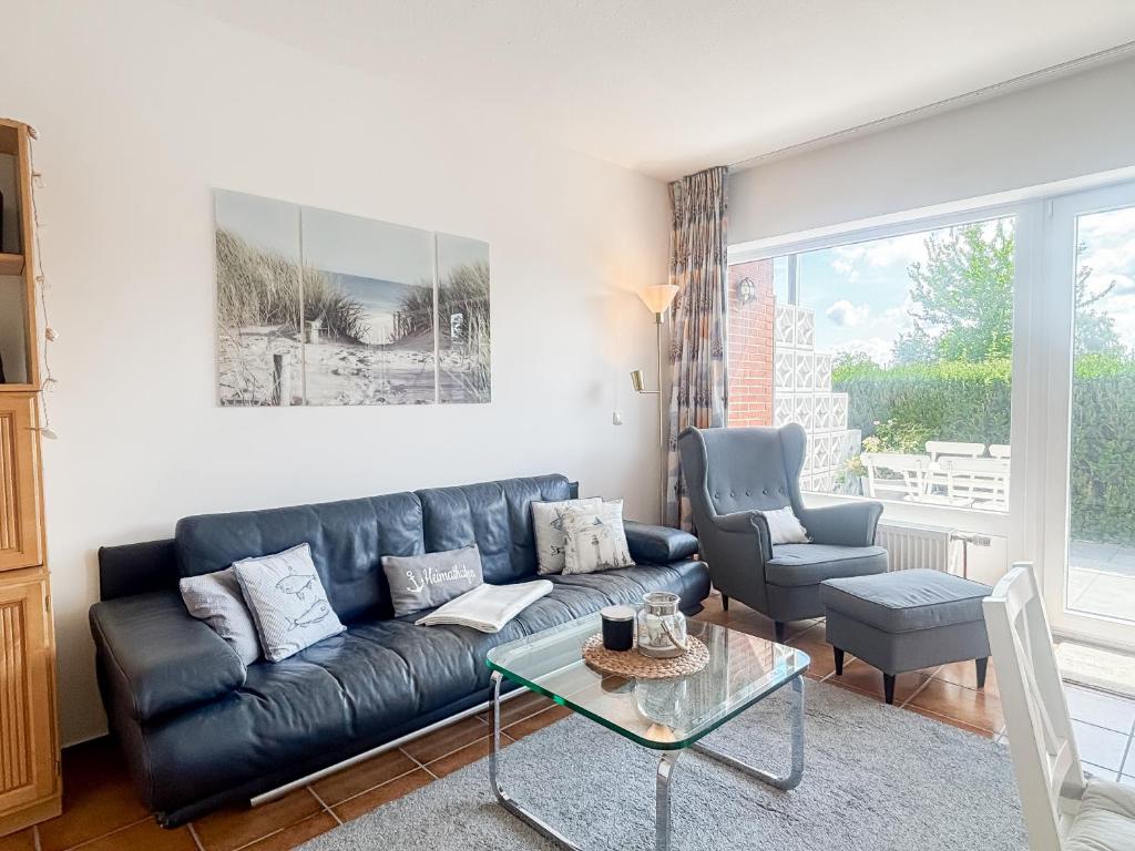 a living room with a black leather couch and a table at Haus Schütz in Grömitz