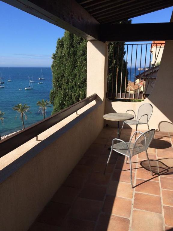 a balcony with a table and chairs and the ocean at Villa La Lézardière in Bandol