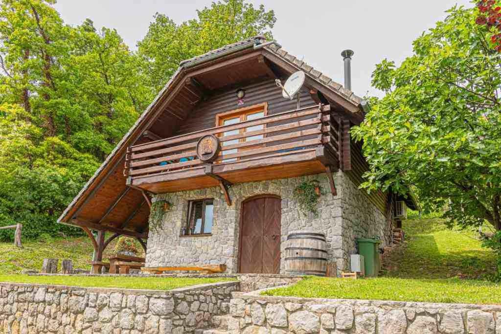 a small house with a wooden roof and a stone wall at Holiday home in Novo mesto - dostava - Kranjska Krain 26036 in Trška Gora