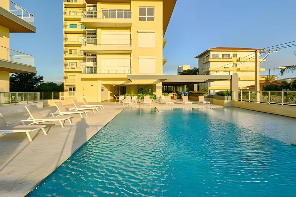 a hotel swimming pool with chairs and a building at Caribbean Nature Sourrounded Refuge Apartment in Juan Dolio