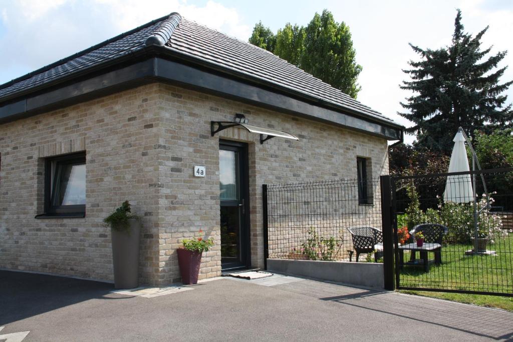 a small brick house with a black gate at Studio a Bois-Bernard 62320 in Bois-Bernard