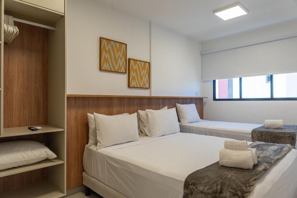 a bedroom with two beds and a window at Studio Design 3 Apt 812 Mandi Hospitalidade in Maceió