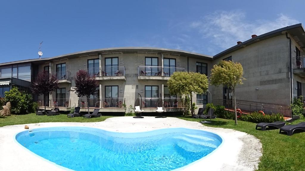 a large building with a large pool in front of it at Peregrina Hotel in Sanxenxo