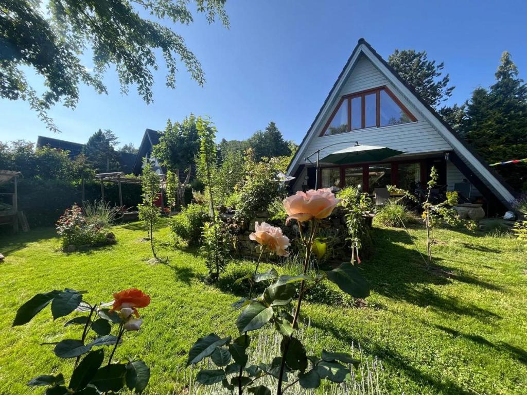 a garden with a house with flowers in the yard at NurdachZeit – Ferienhaus in Schellbronn in Neuhausen