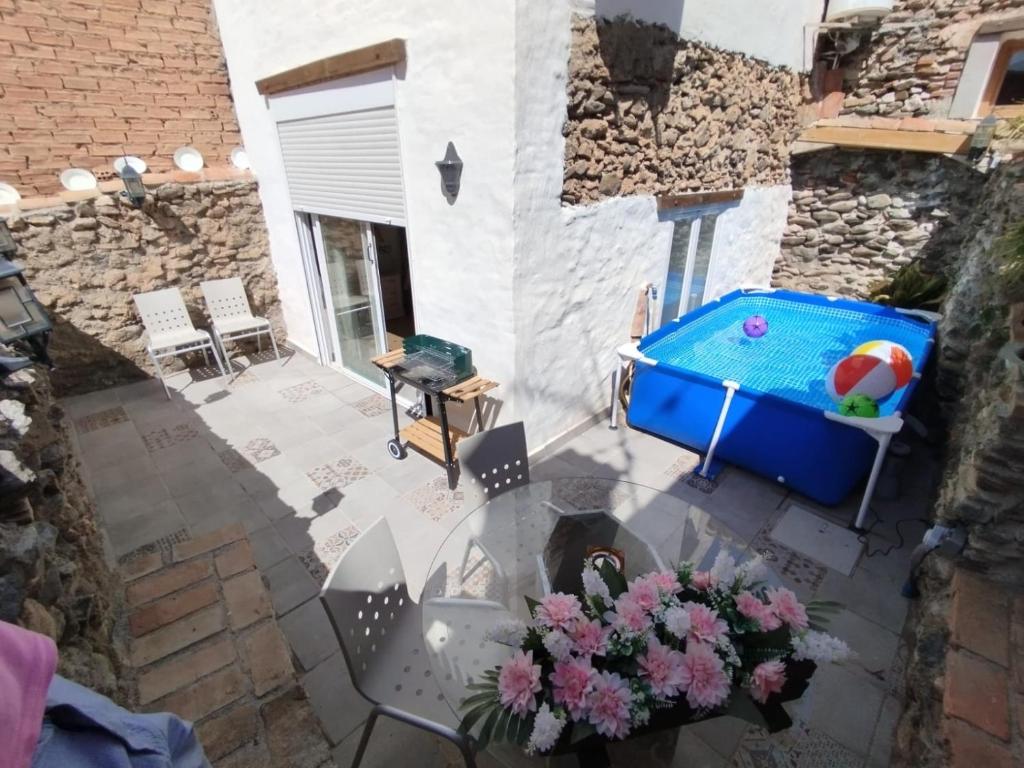 NigüelasにあるCasa Erasのガラステーブルとスイミングプール付きのパティオ