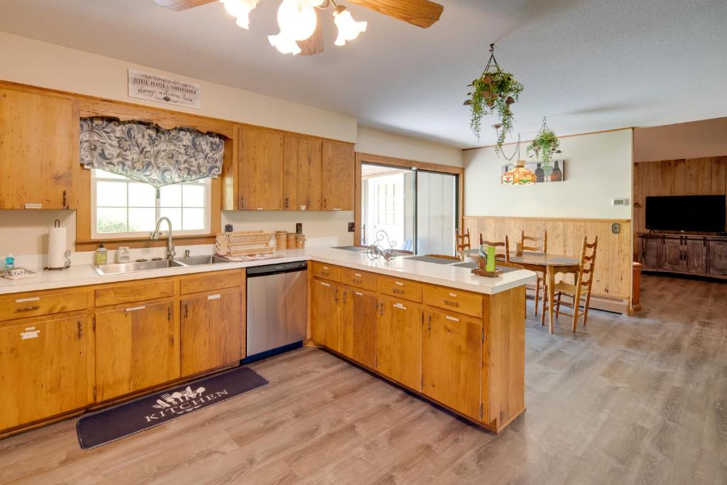 a large kitchen with wooden cabinets and a table at 11 Mi to Asheville Scenic Retreat with Game Room in Candler