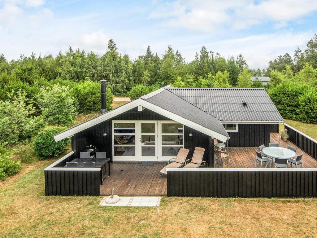 6 person holiday home in Nørre Nebel في Nørre Nebel: منزل صغير مع شرفة وفناء