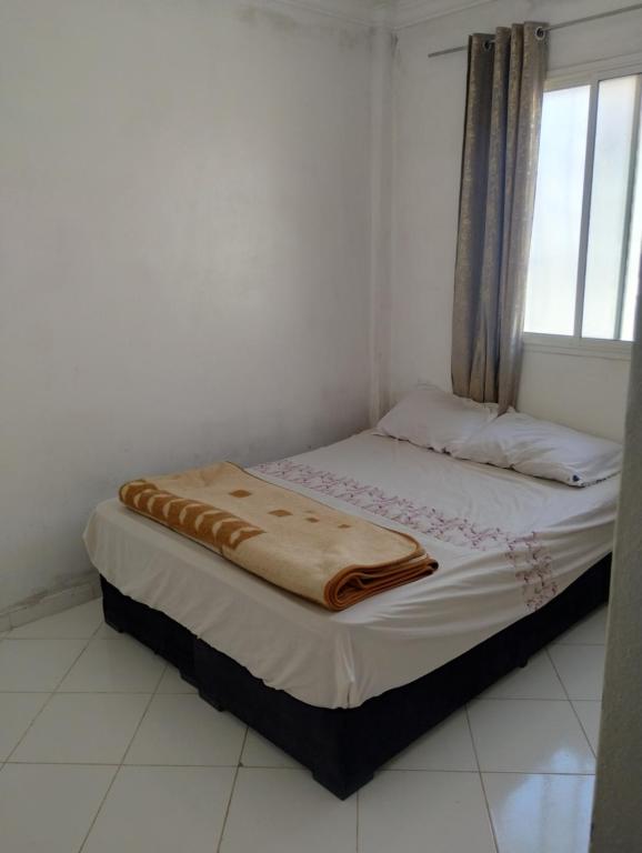 Una cama pequeña en una habitación con ventana. en Tranquil Rental Rooms in Agadir, en Agadir