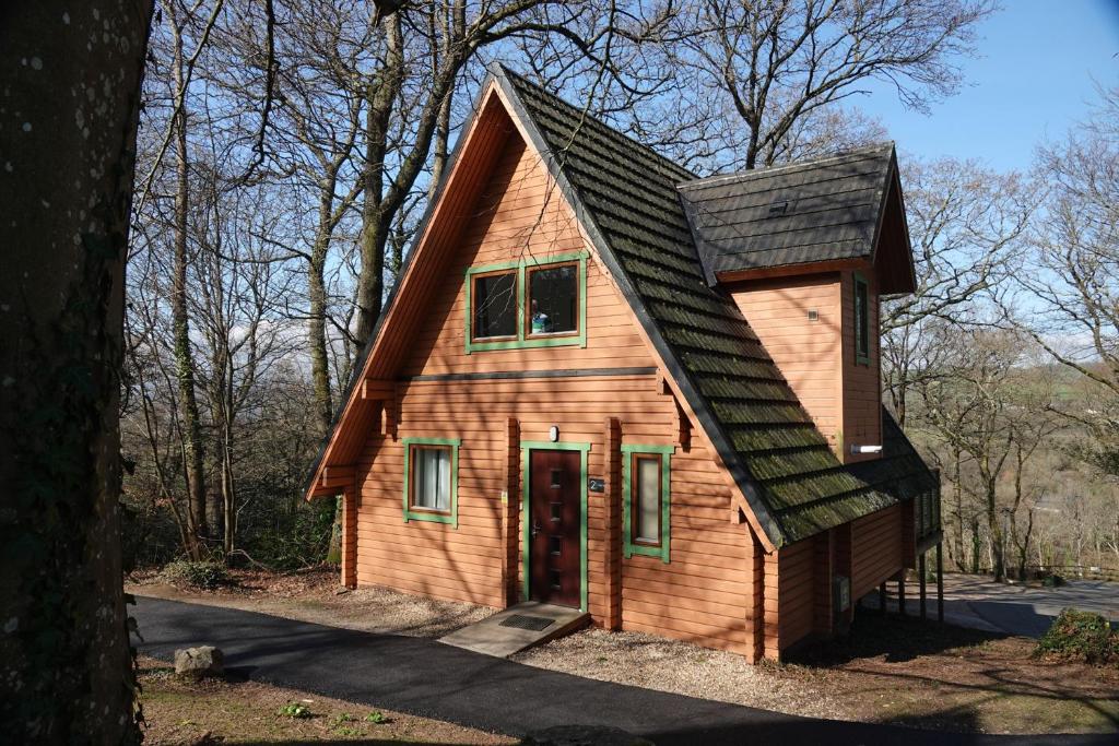 a small wooden house with a gambrel roof at Acorn Lodge in Newton Abbot