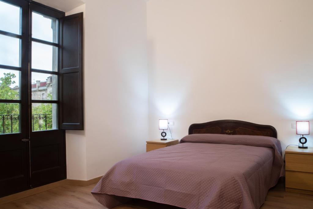 una camera da letto con un letto e due lampade sui comodini di PLAÇA MAJOR 17 2n 1a a Banyoles
