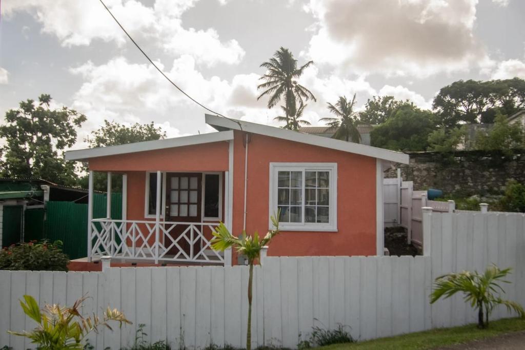 a small house behind a white fence at Vacazure in Saint Joseph